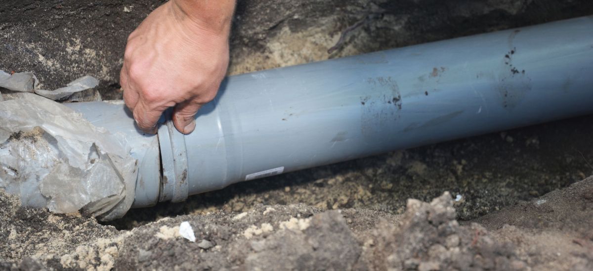 Plumber providing drain cleaning service under a bathroom sink