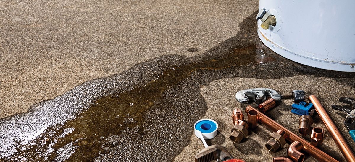 Plumber providing drain cleaning service under a bathroom sink