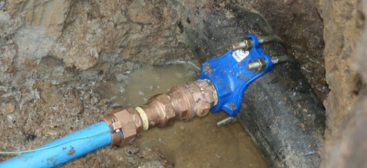 Plumber providing drain cleaning service under a bathroom sink